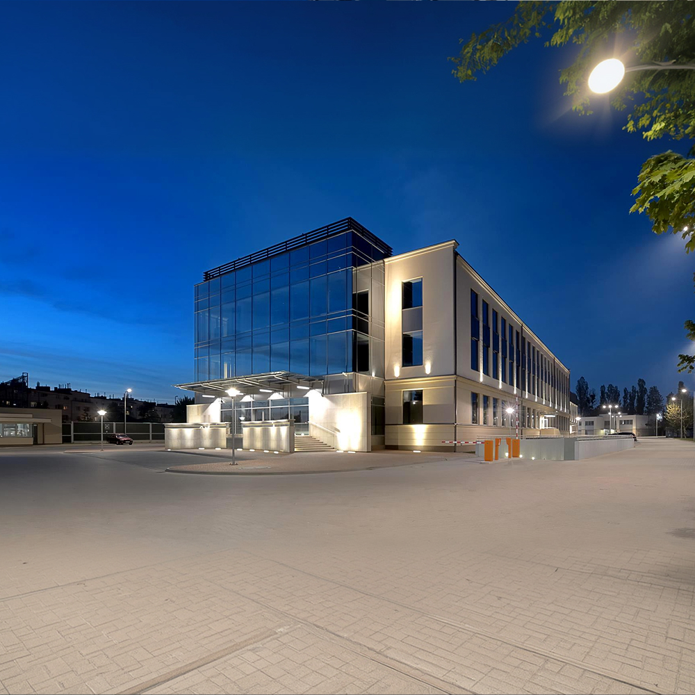 Siedziba biurowa Reflect Group – nowoczesny budynek z przeszklonymi elewacjami sfotografowany o zmierzchu